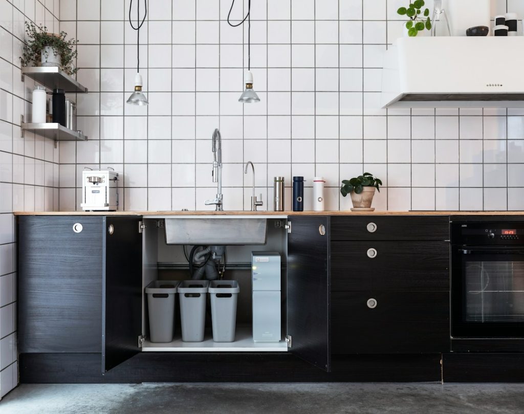 Cuisine moderne avec dispositif de filtration d’eau installé sous l’évier, à côté du rangement