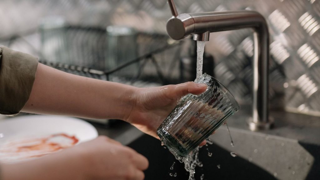 Filtre eau robinet dans une cuisine, verre rempli sous un robinet