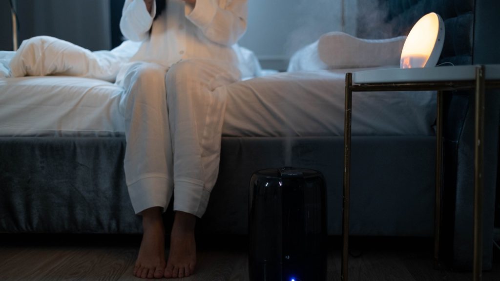 Humidificateur d'air diffusant une brume dans une chambre moderne
