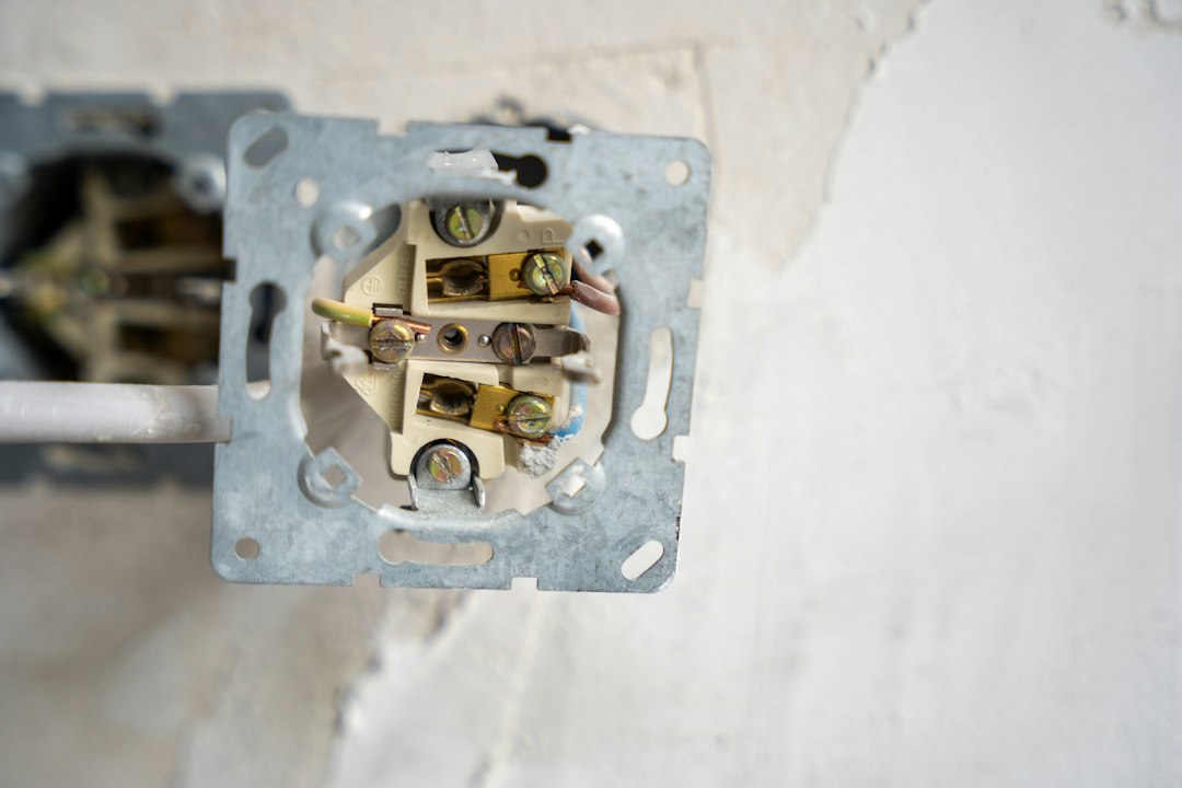 Câbles électriques visibles dans une boîte encastrée dans un mur