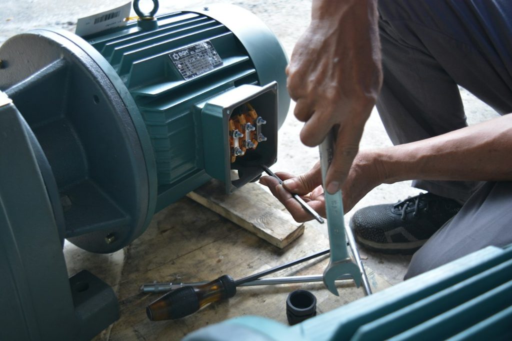 Technicien contrôlant un moteur électrique en atelier