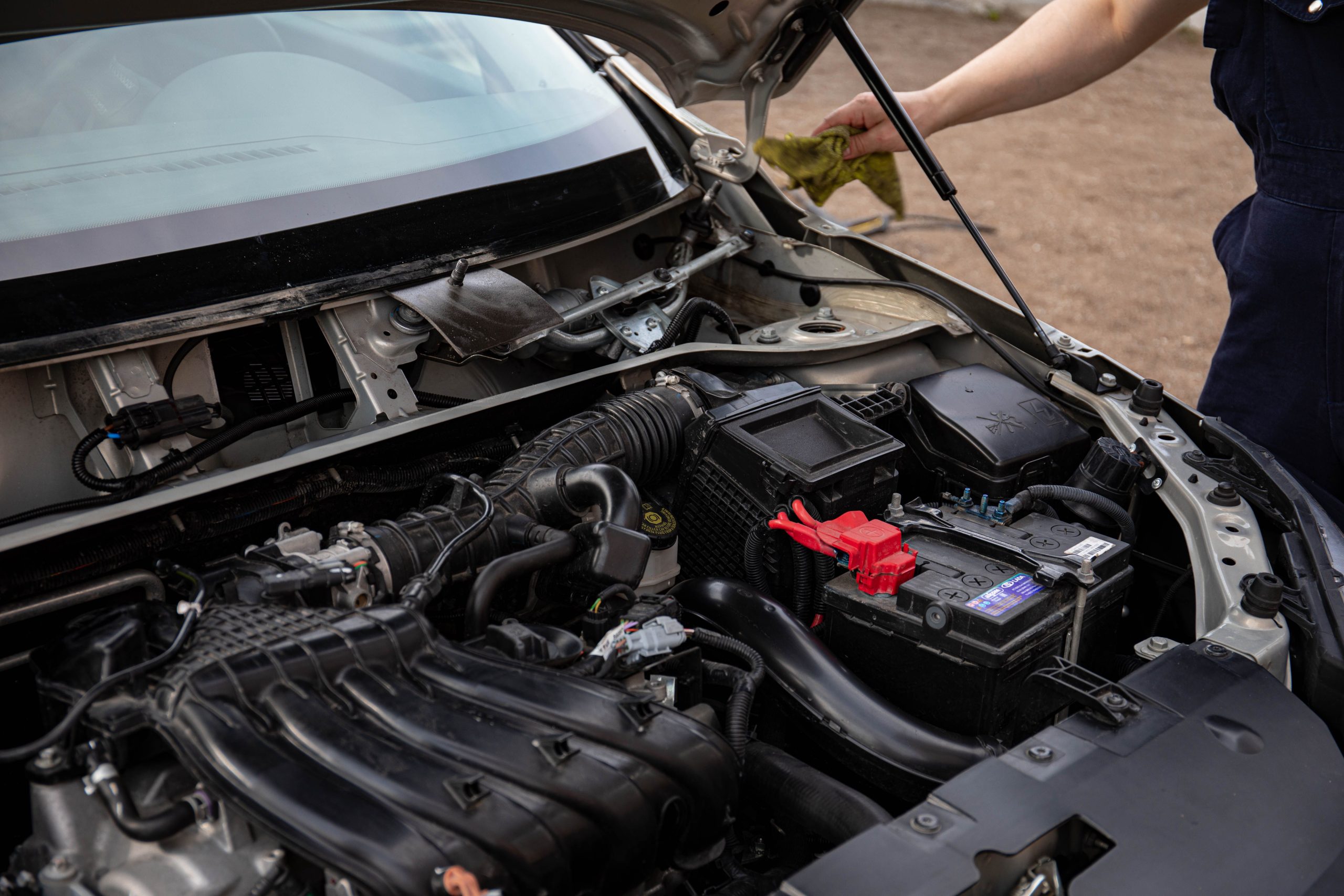 Inspection d'une batterie automobile dans un compartiment moteur
